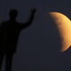 The partial lunar eclipse of July 16, 2019 as seen in Brazil, with a statue in the foreground.